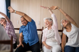 Senior people stretching while sitting on chairs